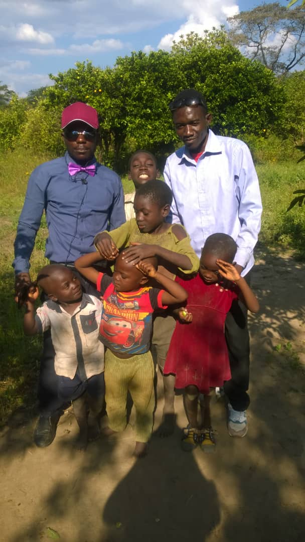 Mentors standing with children during a visit in the community.