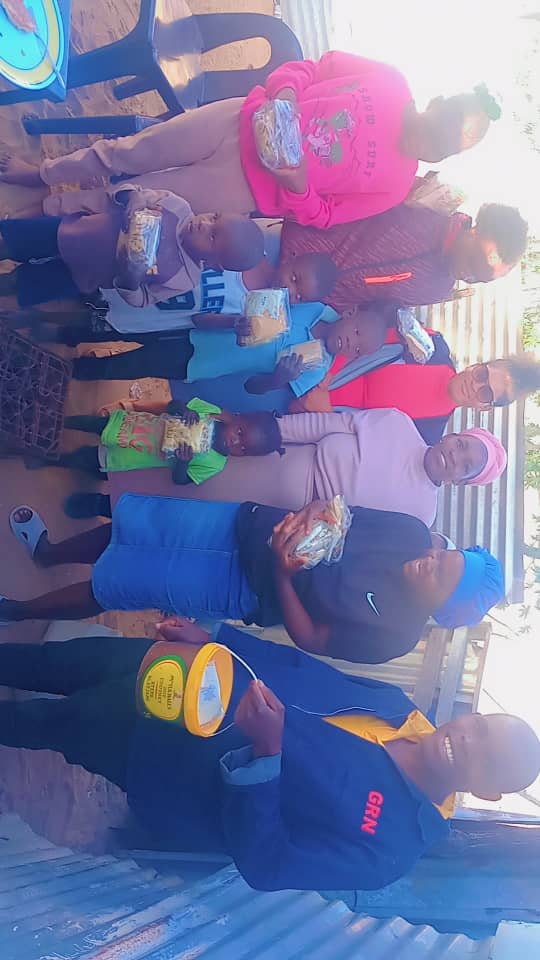 Children and community members receiving food during an outreach visit.